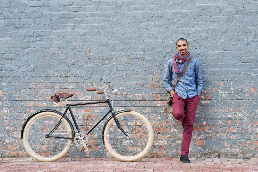 Un homme contre un mur proche d'un vélo